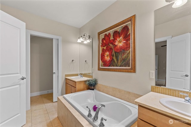 bathroom featuring tile patterned flooring, vanity, and tiled bath