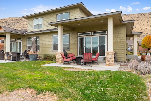 back of property with a yard and a patio