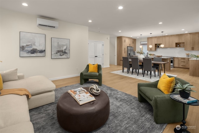 living room featuring wood-type flooring, a wall mounted AC, and sink