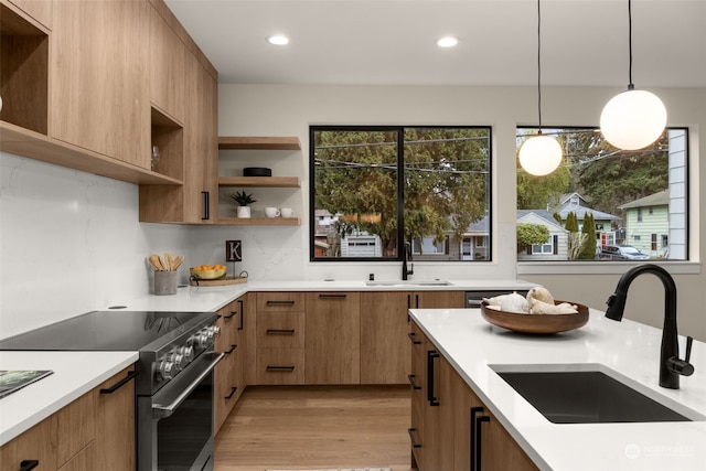 kitchen with stainless steel electric range oven, sink, light hardwood / wood-style flooring, backsplash, and pendant lighting