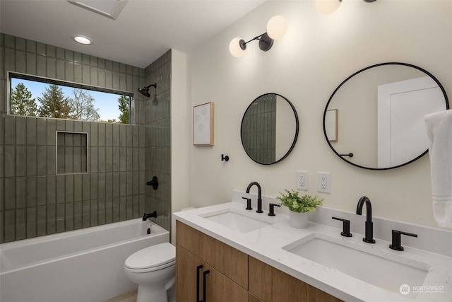 full bathroom with vanity, tiled shower / bath combo, and toilet