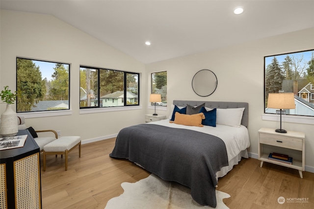 bedroom with light hardwood / wood-style floors and lofted ceiling