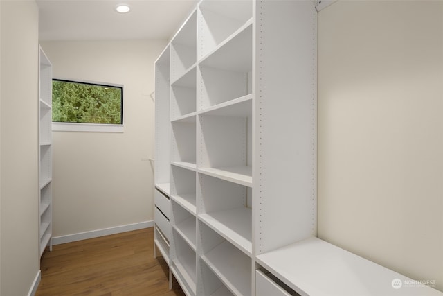 walk in closet with hardwood / wood-style floors and vaulted ceiling