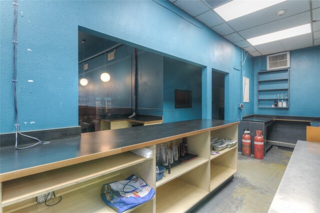 interior space with a paneled ceiling and concrete floors