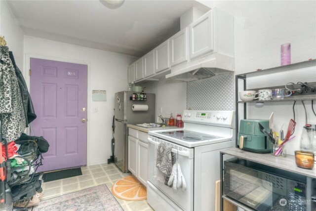 kitchen featuring stainless steel fridge, tasteful backsplash, sink, white electric stove, and white cabinetry