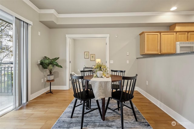 dining area featuring light hardwood / wood-style floors and ornamental molding