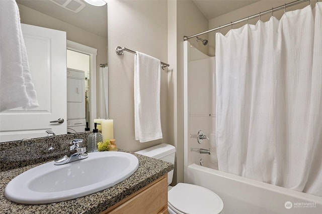 full bathroom featuring shower / bath combination with curtain, vanity, toilet, and stacked washer and clothes dryer