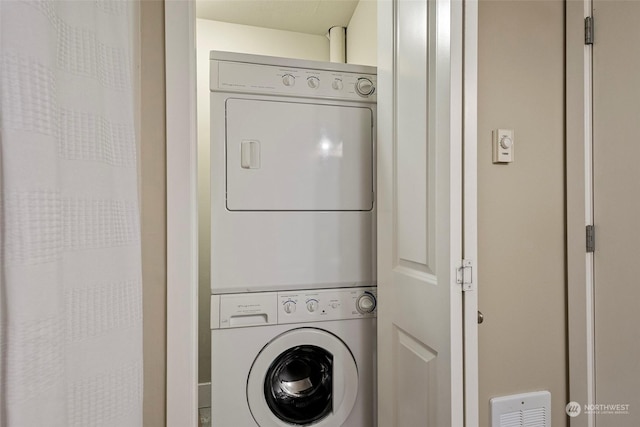 washroom featuring stacked washer and clothes dryer