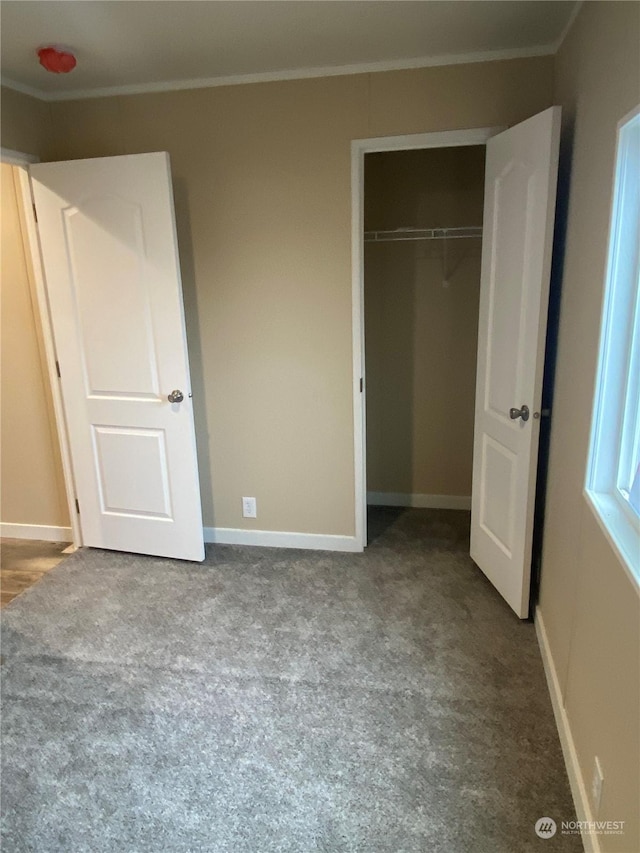 unfurnished bedroom with light colored carpet, a closet, and crown molding