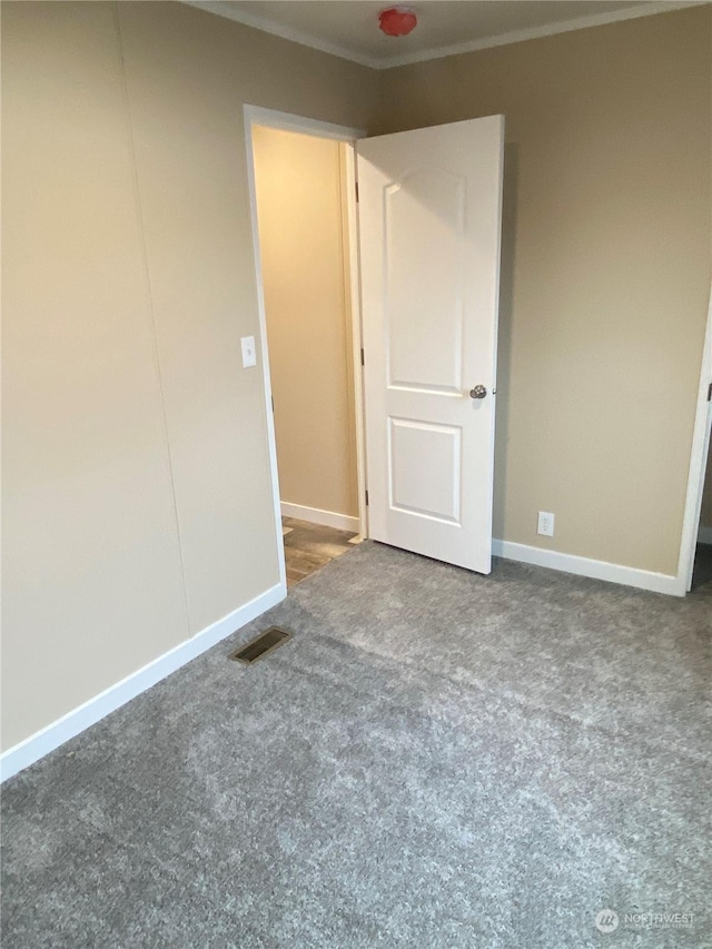 unfurnished bedroom featuring crown molding and carpet