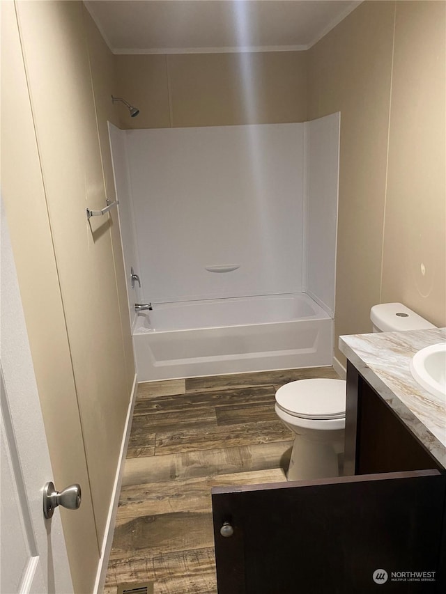 full bathroom with vanity, wood-type flooring, toilet, shower / bathing tub combination, and ornamental molding