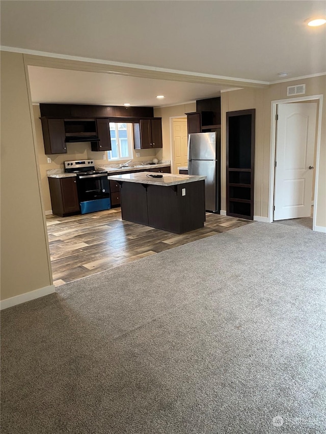 kitchen with dark brown cabinetry, sink, stainless steel appliances, light hardwood / wood-style flooring, and a kitchen island