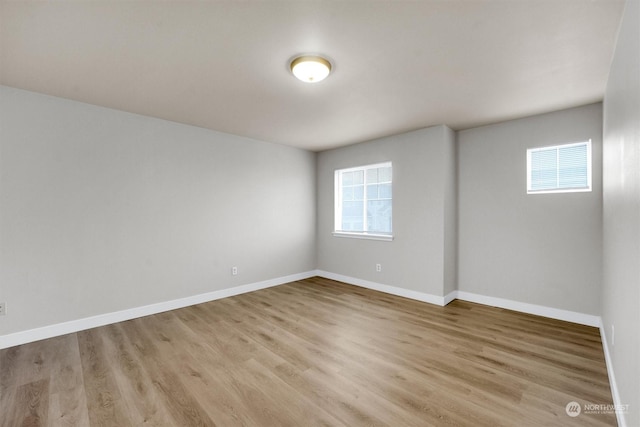 spare room featuring plenty of natural light and light hardwood / wood-style flooring