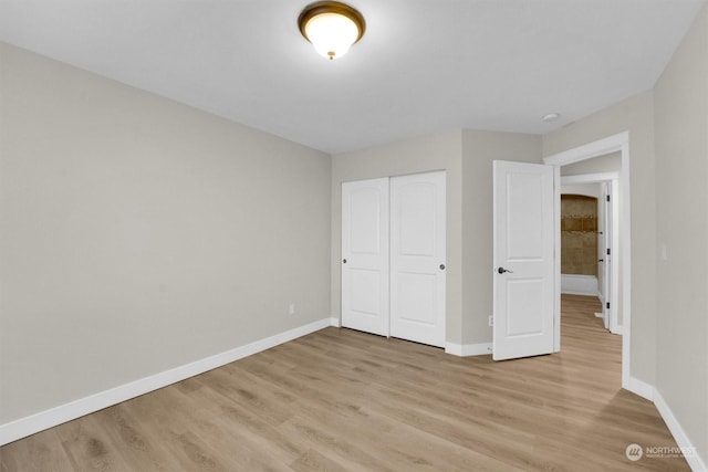 unfurnished bedroom featuring a closet and light hardwood / wood-style flooring