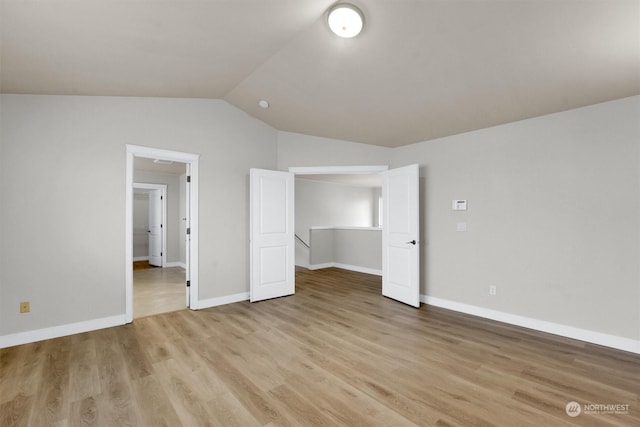 unfurnished bedroom featuring light hardwood / wood-style flooring and lofted ceiling