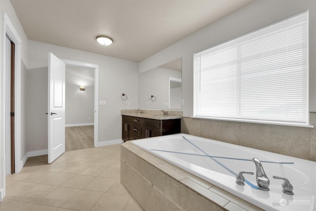 bathroom featuring tiled tub, tile patterned flooring, and vanity