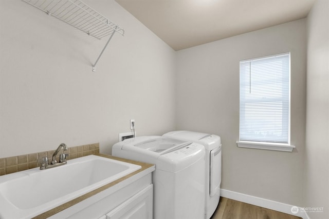 washroom featuring hardwood / wood-style floors, sink, and washer and dryer