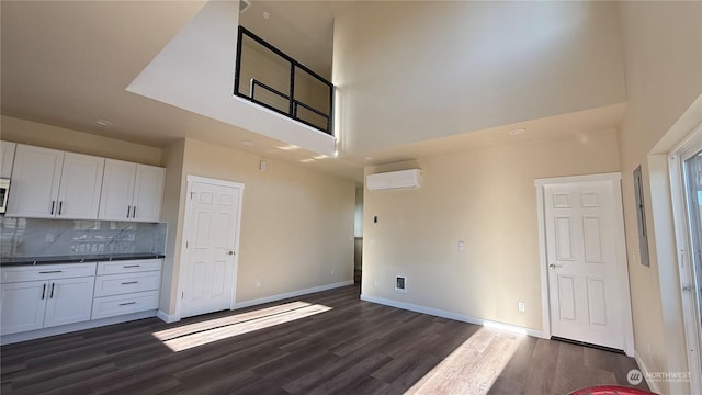 kitchen featuring dark hardwood / wood-style floors, white cabinetry, and a wall mounted AC