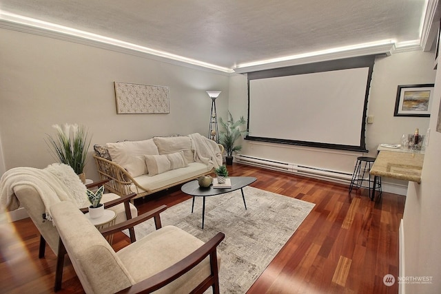 home theater with a textured ceiling, dark hardwood / wood-style flooring, baseboard heating, and crown molding