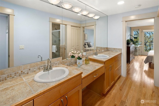 bathroom featuring vanity, a shower with shower door, and wood-type flooring