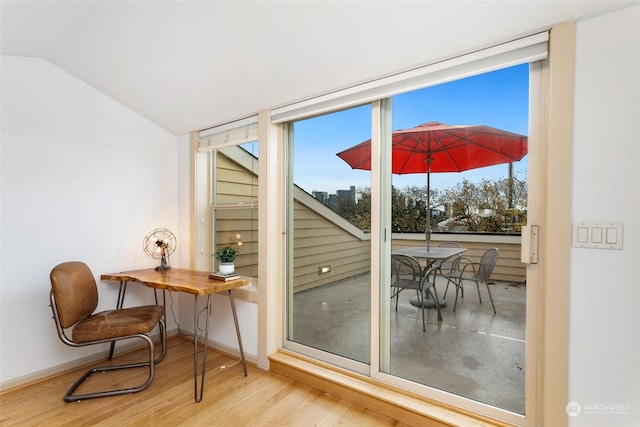 doorway featuring hardwood / wood-style flooring and vaulted ceiling