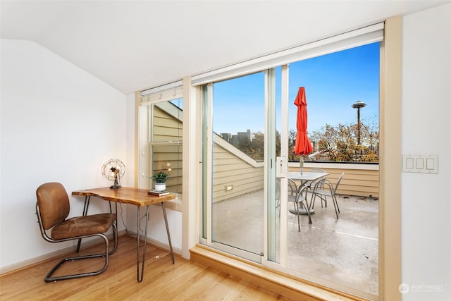 doorway to outside featuring vaulted ceiling and light wood-type flooring