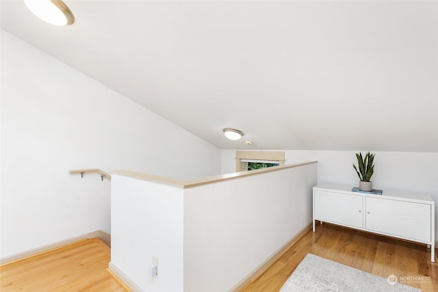 hall featuring light hardwood / wood-style flooring and vaulted ceiling