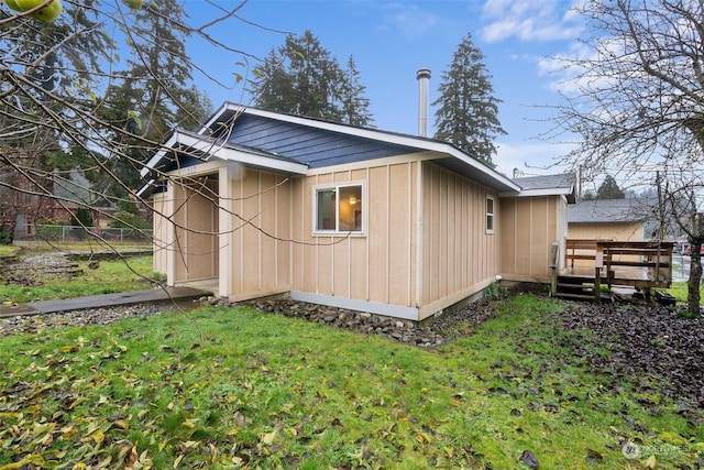 view of home's exterior featuring a deck and a yard