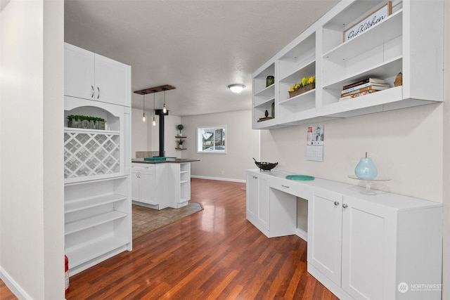 kitchen featuring pendant lighting, white cabinetry, and dark wood-type flooring