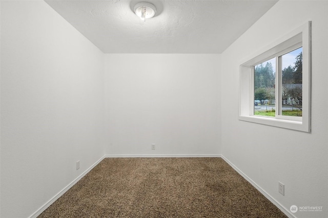 carpeted empty room featuring a textured ceiling