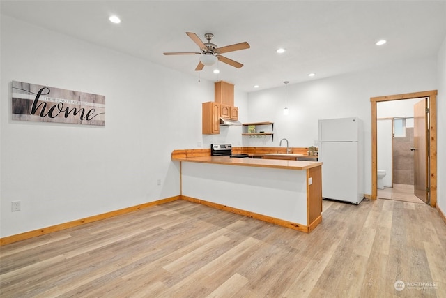 kitchen with sink, white refrigerator, kitchen peninsula, stainless steel range with electric cooktop, and light wood-type flooring