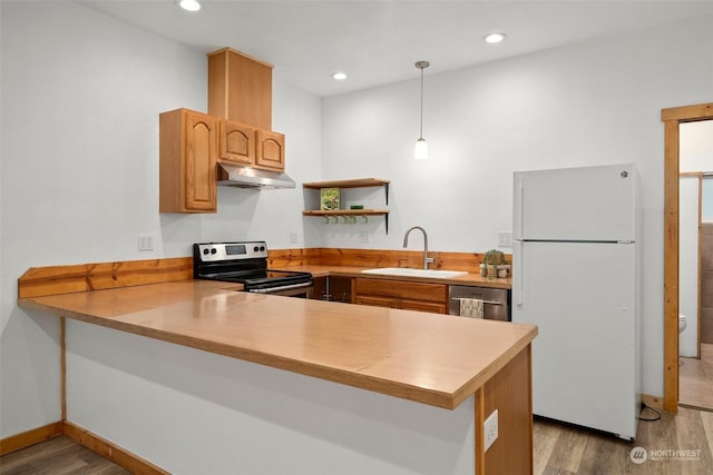 kitchen with pendant lighting, kitchen peninsula, sink, and appliances with stainless steel finishes