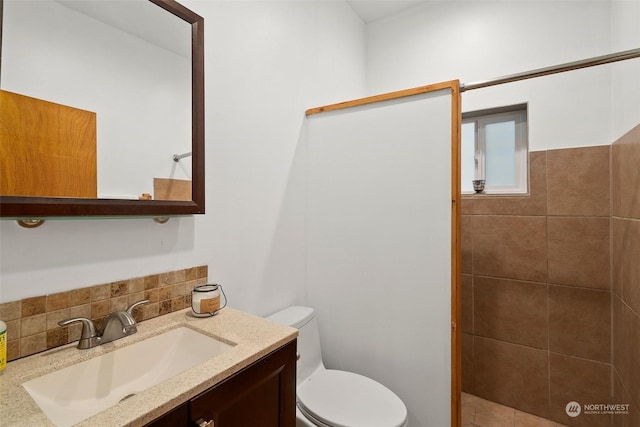 bathroom with decorative backsplash, vanity, and toilet