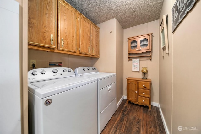 washroom with washing machine and dryer, dark hardwood / wood-style flooring, cabinets, and a textured ceiling