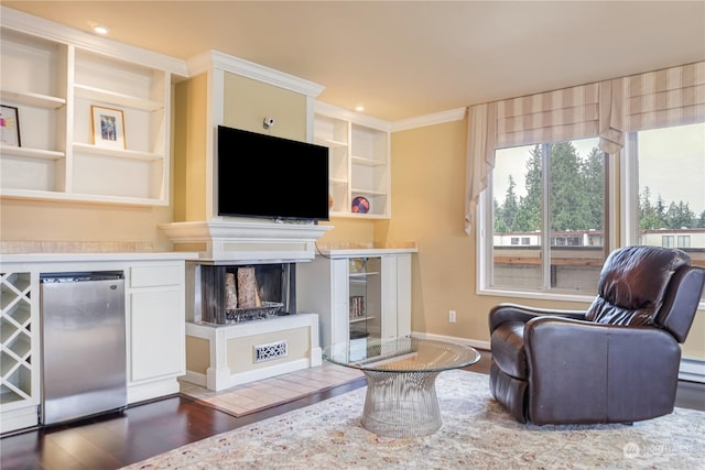 living room featuring a multi sided fireplace, built in shelves, dark hardwood / wood-style floors, and ornamental molding