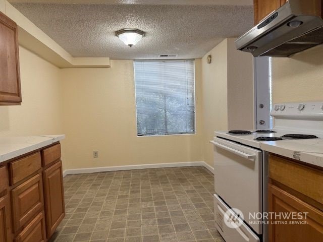 kitchen featuring white range with electric stovetop and a textured ceiling