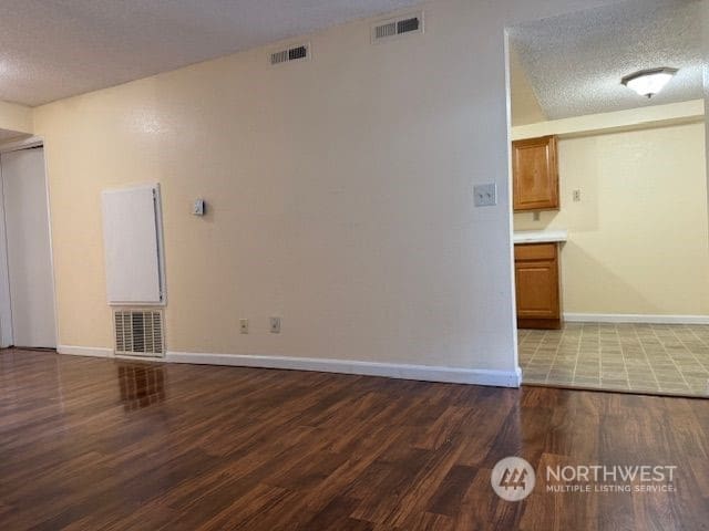 empty room featuring a textured ceiling and hardwood / wood-style flooring