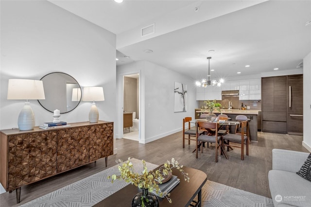 living room with sink, a notable chandelier, and hardwood / wood-style flooring