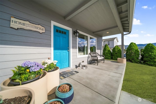 property entrance with a yard and covered porch