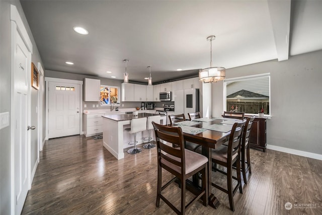 dining space with dark hardwood / wood-style floors and an inviting chandelier