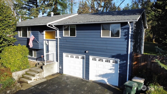 view of front facade with roof with shingles and an attached garage