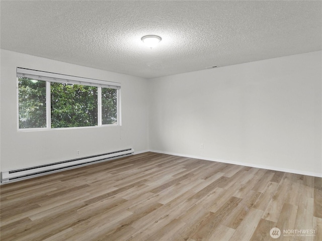 unfurnished room featuring light wood-style floors, baseboards, a baseboard heating unit, and a textured ceiling