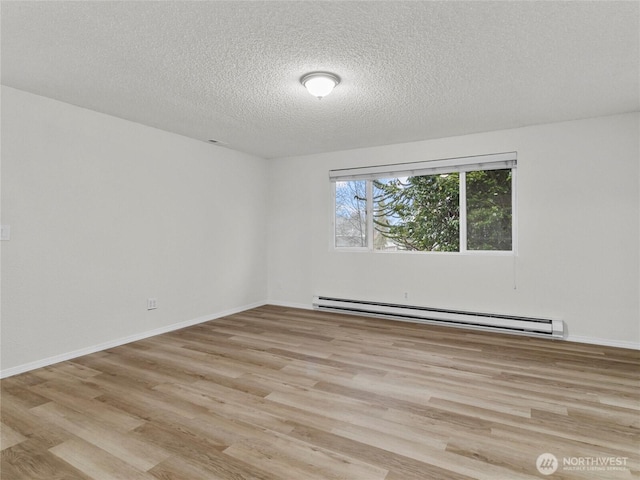 empty room with a baseboard radiator, baseboards, light wood-style flooring, and a textured ceiling