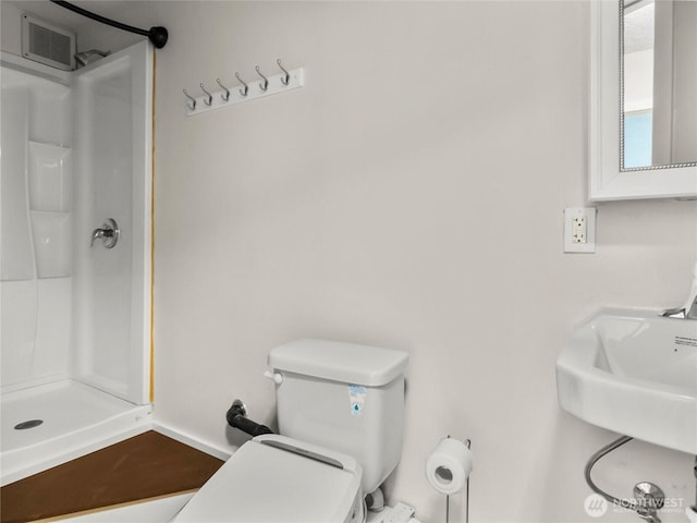 full bathroom with toilet, a sink, a shower stall, and visible vents