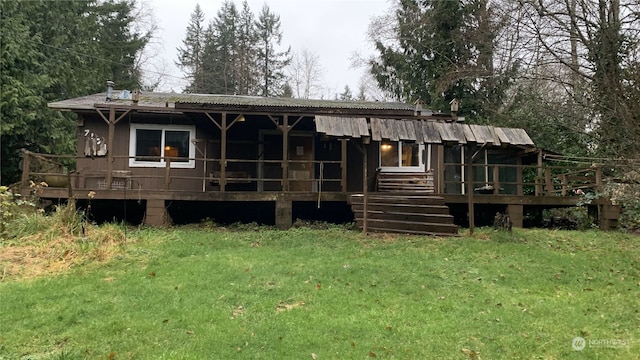 rear view of property featuring a deck and a lawn