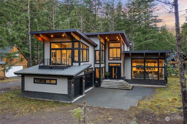 back house at dusk with a garage