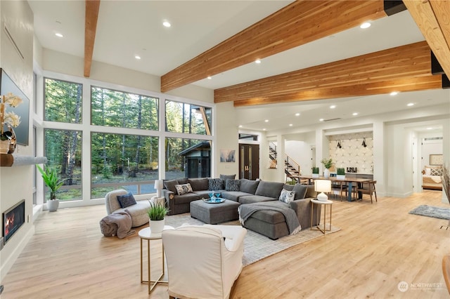 living room with beamed ceiling and light hardwood / wood-style flooring