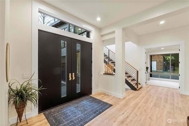 foyer entrance with light hardwood / wood-style flooring and french doors