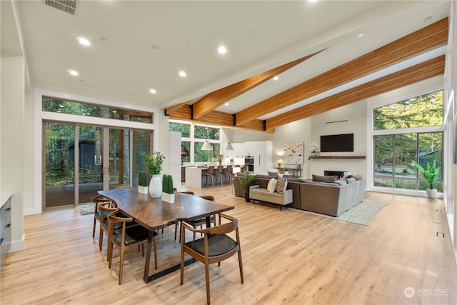 dining area with beamed ceiling and light hardwood / wood-style floors