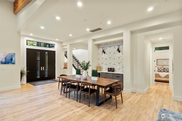 dining area with beamed ceiling and light hardwood / wood-style flooring